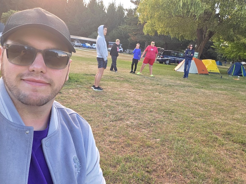Group of creators at camp with tents set up in the background.